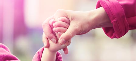 Adult and child holding hands