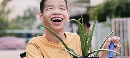 Person smiling with aloe vera plant