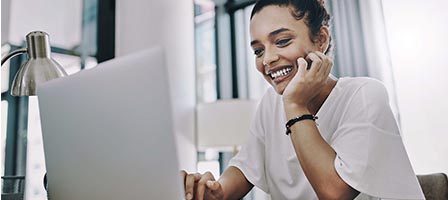 Woman smiling while using a laptop