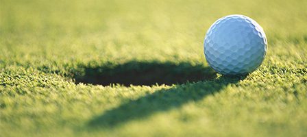 Golf ball near hole on green
