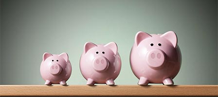Three pink piggy banks of varying sizes