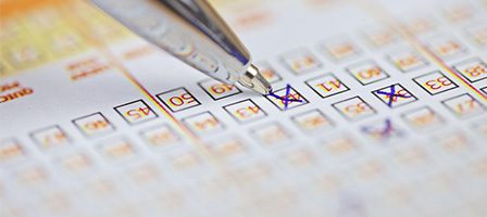 Pen marking numbers on lottery ticket