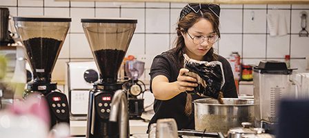 Coffee shop scene with focused barista