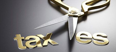 Scissors cutting the word taxes