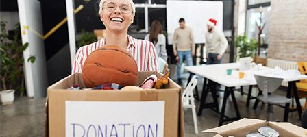 Person holding donation box, smiling
