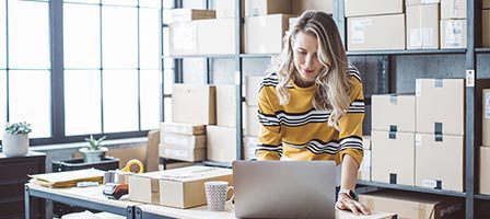 Woman working on laptop in warehouse
