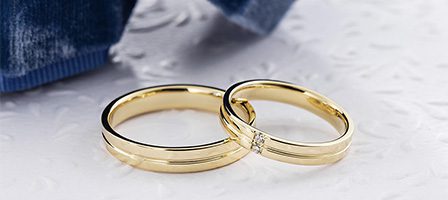 Pair of gold bands near blue fabric