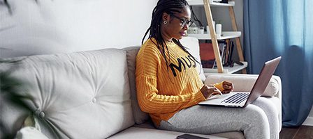 Woman typing on laptop in living room