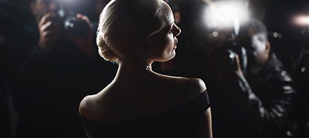 Celebrity facing paparazzi cameras at night