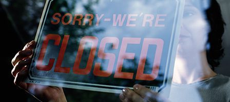 Person holding closed sign