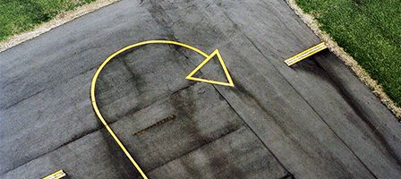 Yellow U-turn arrow on asphalt