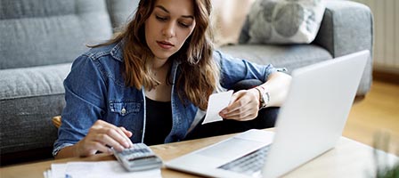 Person budgeting at home using a calculator