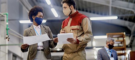 Workers discussing plans in a factory