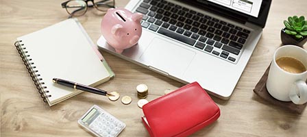 Laptop with piggy bank and calculator