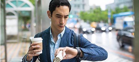Person with coffee cup checking time