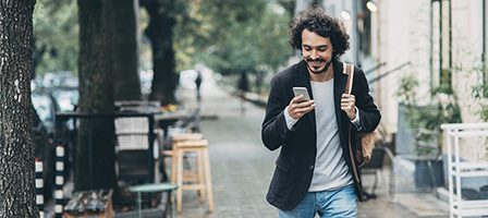 Man walking while checking phone