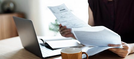 Laptop, documents, and coffee cup on table