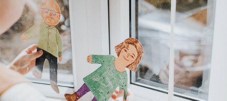 Handmade paper dolls near window