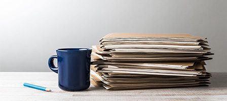 Office desk with files and pencil.