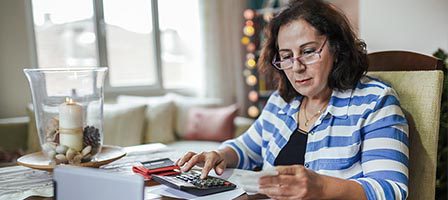 Woman calculating expenses at home