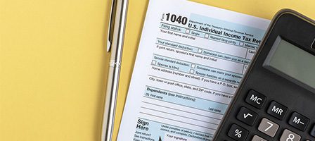 Tax form with pen and calculator