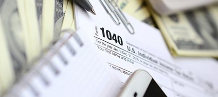 Tax documents and smartphone on desk